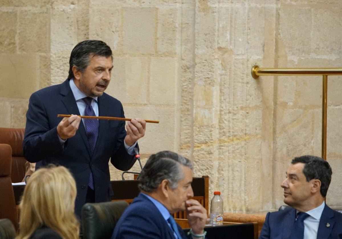 El portavoz del PP, Toni Martín, exhibe una vara de medir ante la mirada de Juanma Moreno.