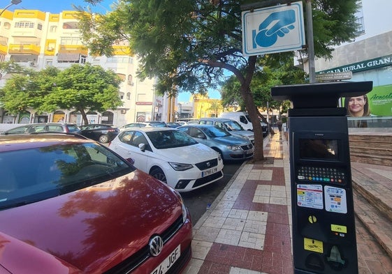 Vehículos estacionados junto a un parquímetro.