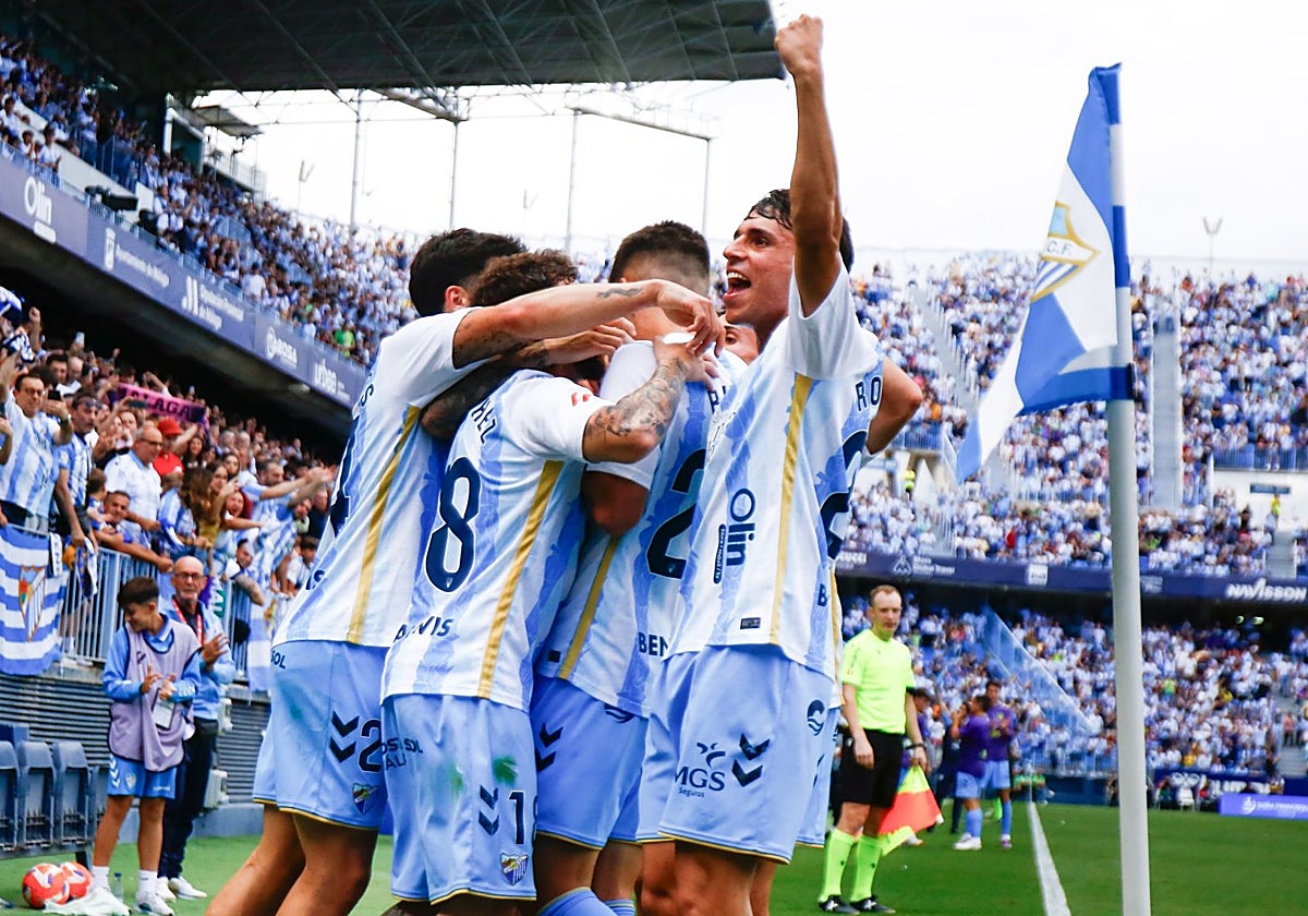 Los jugadores del Málaga abrazan a Antoñito tras marcar el penalti.