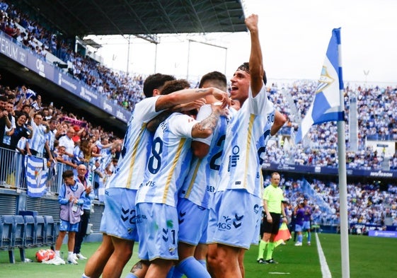 Los jugadores del Málaga abrazan a Antoñito tras marcar el penalti.
