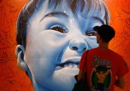 Lalone firma uno de los 21 murales hechos expresamente para la exposición.