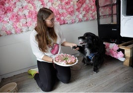 Simona junto a su perro Maco en el interior de la tienda.