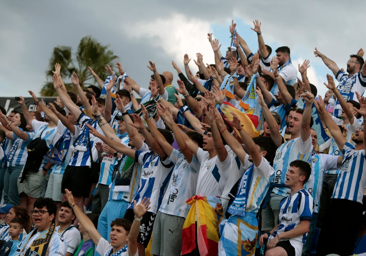 Aficionados del Málaga desplazados a Elda cantan el himno del conjunto blanquiazul.