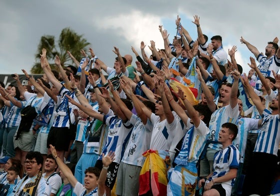 Aficionados del Málaga desplazados a Elda cantan el himno del conjunto blanquiazul.