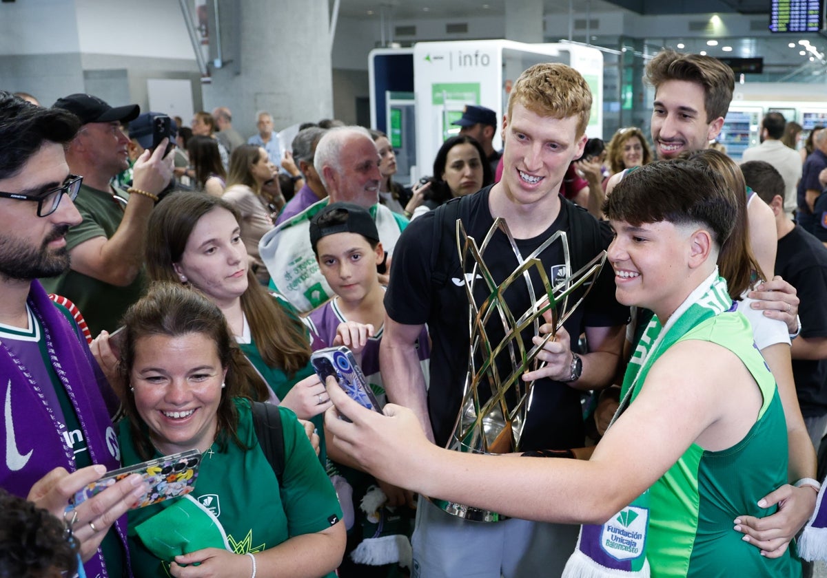 Alberto Díaz, trofeo en mano, se fotografía con unos aficionados en el aeropuerto.