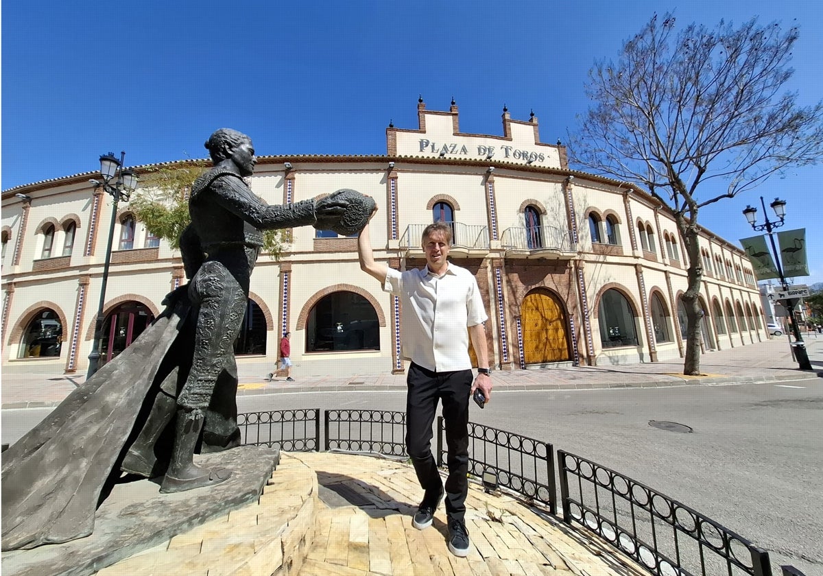 Marc Skarman, actual propietario de la plaza de toros de Fuengirola, posa junto a la escultura al torero Antonio José Galán, situada delante de la plaza.