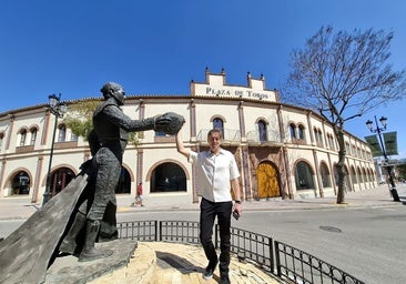 Marc Skarman, actual propietario de la plaza de toros de Fuengirola, posa junto a la escultura al torero Antonio José Galán, situada delante de la plaza.