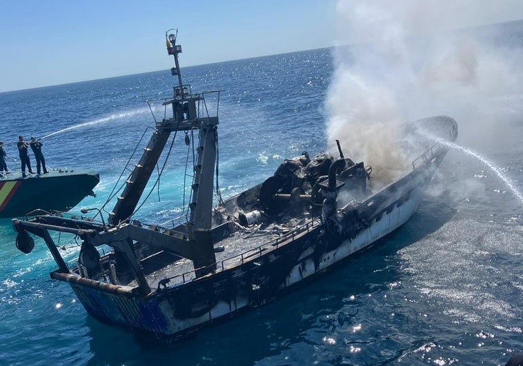 El pesquero incendiado.