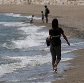Una persona pasea por la orilla del mar.