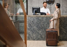 Recepcionista de un hotel atiende a una turista.