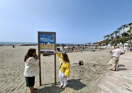 A la izquierda, la concejal Presi Aguilera observa junto a una miembro de su equipo uno de los carteles que van a ser instalados en Playa Bonita.