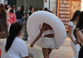 Una turista se desplaza por el Centro de Málaga hacia la playa.