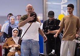 Kayed es abrazado por su cuñada, Soad, en la terminal de llegadas de Málaga ante la mirada de su esposa y sus hijos.