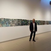 El autor posa con su pintura de 18 metros.