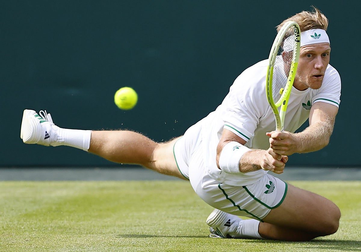 Una increíble estirada de Davidovich, arrodillado sobre la hierba, en el tercer set del duelo de este viernes ante Fritz en la pista central de Wimbledon, repleta de público.