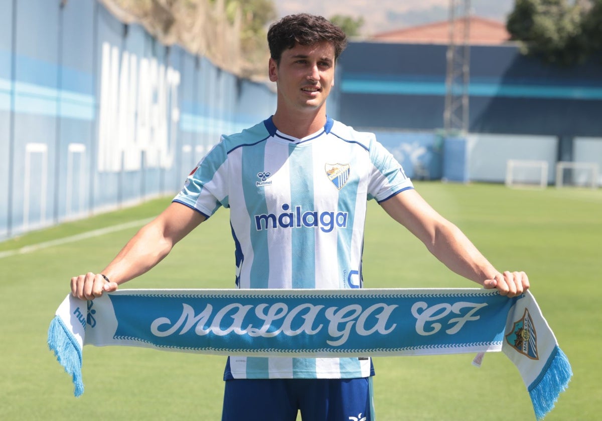 Carlos Dotor posa este jueves con la indumentaria blanquiazul y una bufanda del Málaga.