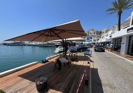 Montaje de la terraza de un restaurante en Puerto Banús en las plazas de aparcamiento de enfrente del establecimiento.