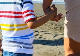 Imagen del pequeño junto a su madre en la playa de El Dedo.