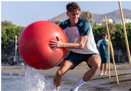 Adrián Niño, realizando un ejercicio físico en la playa de El Palo en su primer entrenamiento.