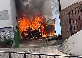 Imagen del vehículo ardiendo, este domingo en el casco histórico de Torrox.