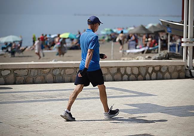 Un hombre anda por el Paseo Marítimo Ciudad de Melilla de Málaga.