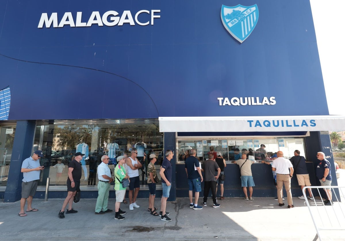 Aficionados del Málaga hacen cola en las taquillas del estadio para comprar los abonos.