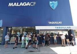 Aficionados del Málaga hacen cola en las taquillas del estadio para comprar los abonos.