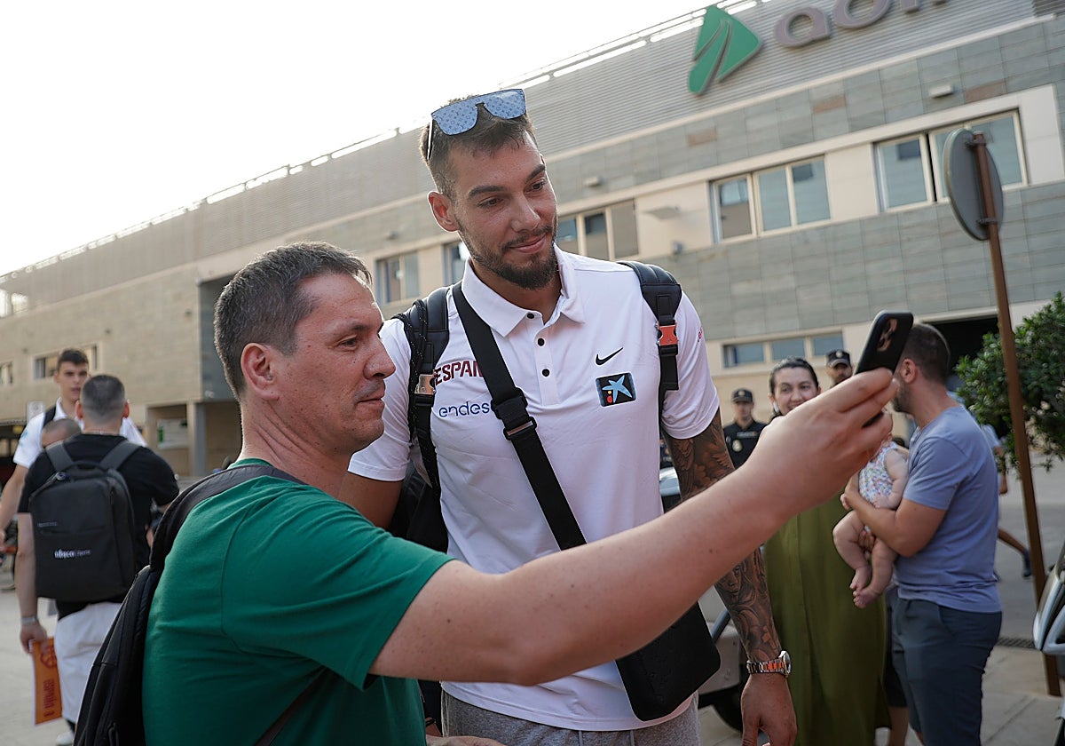Un aficionado se hace una fotografía con Willy Hernangómez.