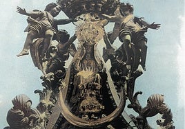 La Virgen de la Victoria, en una foto coloreada, vestida con ropajes y presidiendo su antiguo templete.