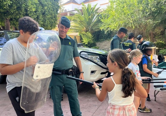 Un niño y una niña participantes en la actividad, con un escudo y una defensa antidisturbios.
