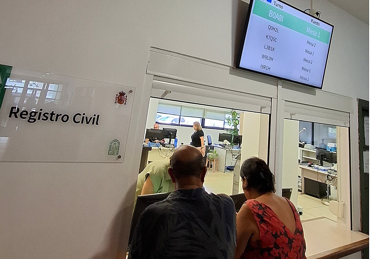 Dos usuarios esperan a ser atendidos en el Registro Civil.