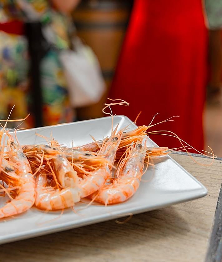 Imagen secundaria 2 - Arriba, el 'pescaíto' frito no puede faltar estos días. Abajo, a la izquierda, pocos establecimientos se resisten a incluir el jamón en su carta. A la derecha, las gambas, otro de los platos que más se ven en las mesas.