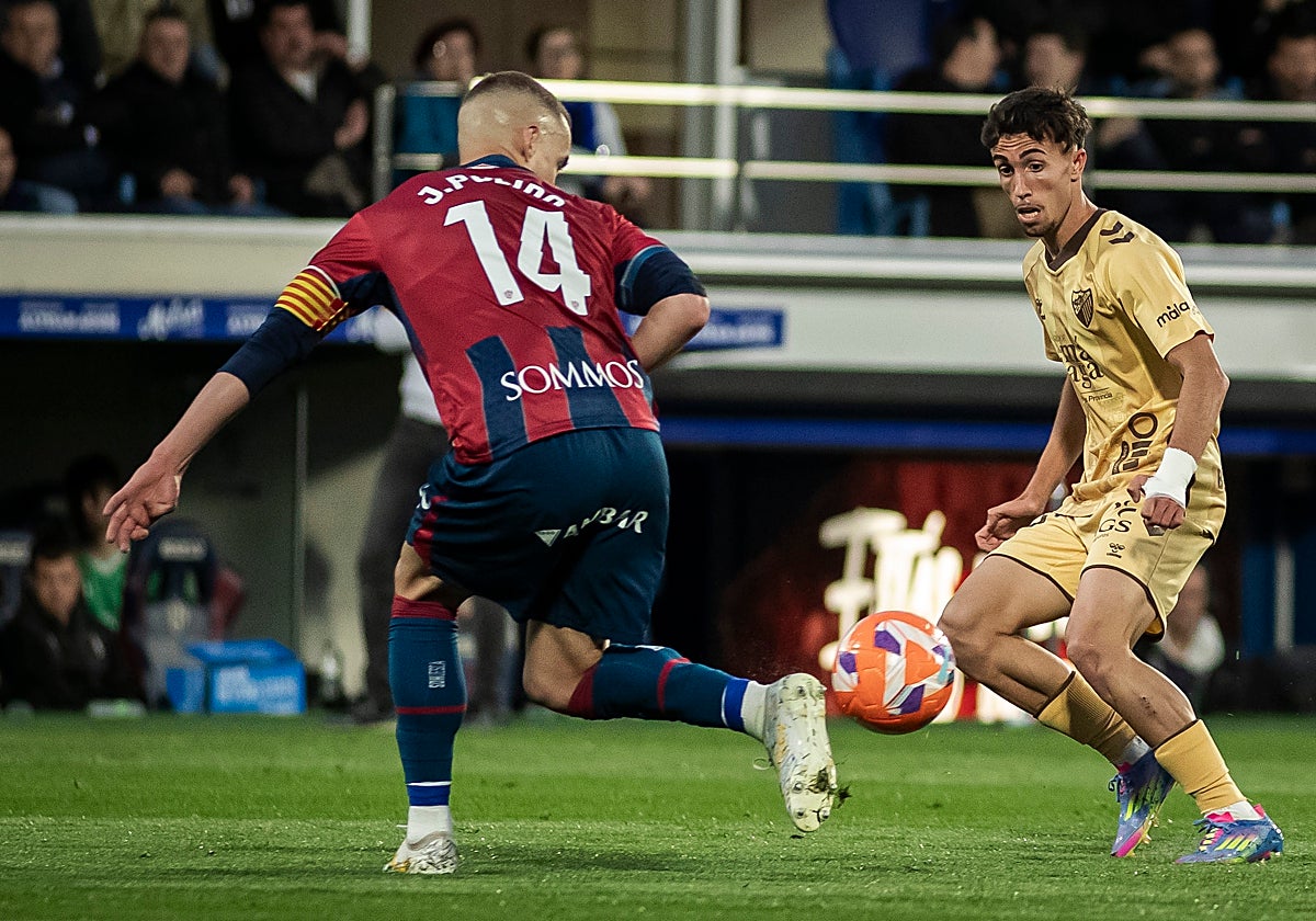 Larrubia encara a Jorge Pulido, en el duelo liguero en Huesca del Málaga la pasada campaña, que fue en la trigésima quinta jornada.