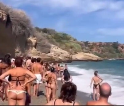 Imagen de bañistas observando la actuación de los socorristas en la playa nerjeña de Burriana.