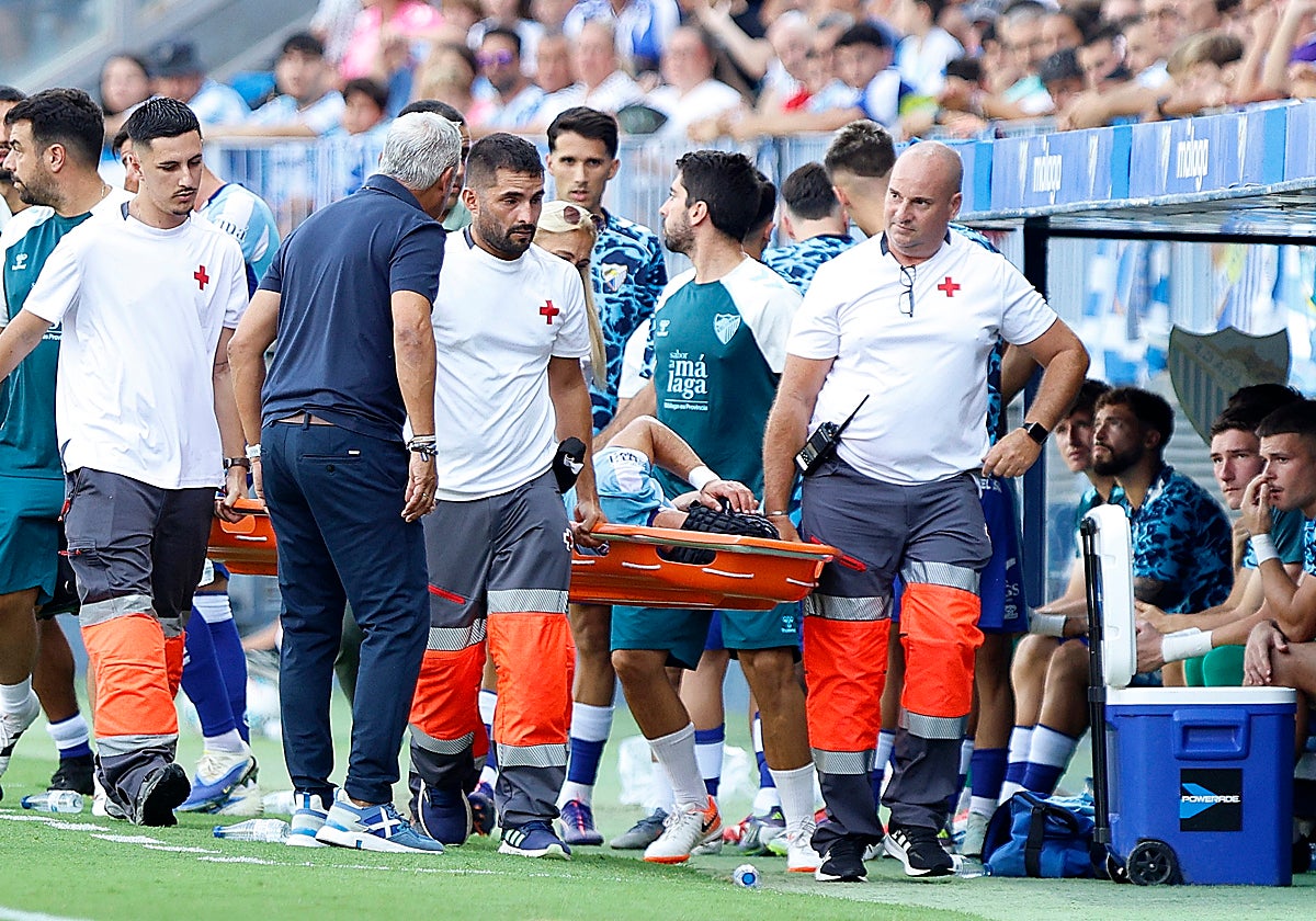 Pellicer se interesa por el estado de Luismi mientras abandonaba el terreno de juego de La Rosaleda en camilla.