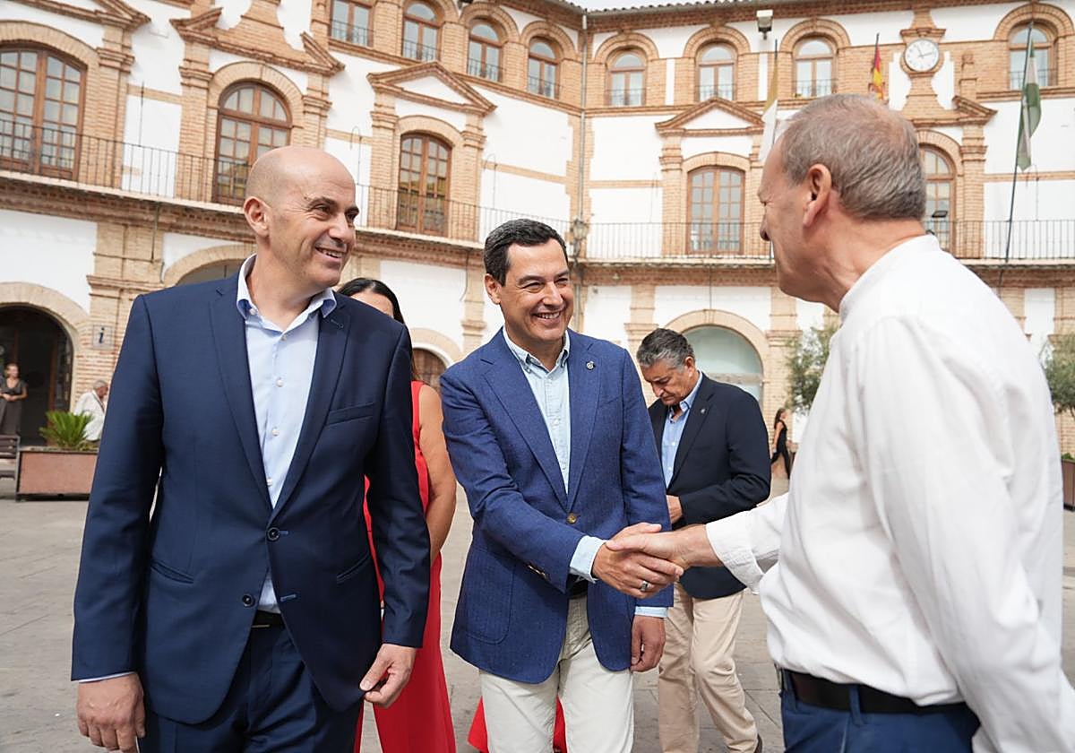 El presidente de la Junta de Andalucía, Juanma Moreno, junto al alcalde de Archidona, Manuel Almohalla, saluda a un vecino durante su visita al municipio.