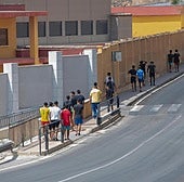 Menores migrantes caminan junto a un centro de acogida en la ciudad autónoma de Ceuta.