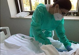 Una enfermera atiende a un paciente.