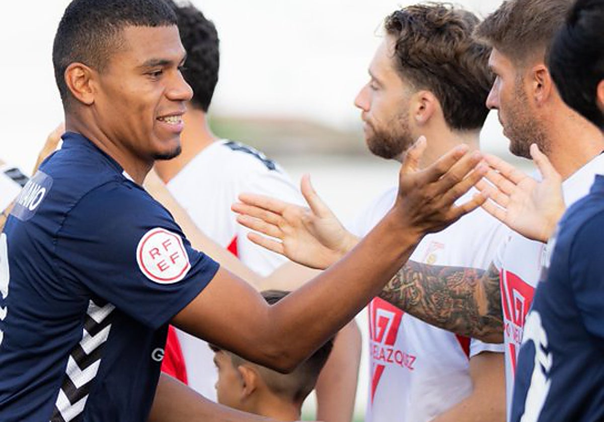 El saludo inicial entre los dos equipos, La Unión Atlético (de azul marino) y el Antoniano (blanco), con las dos equipaciones del club sevillano.