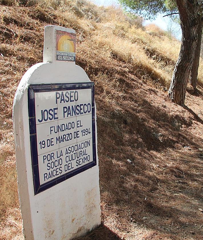 Imagen secundaria 2 - Mosaico en la entrada del casco urbano que alude a los verdiales. Abajo, una de las calles del centro de esta aldea y paseo dedicado a 'Panseco'.