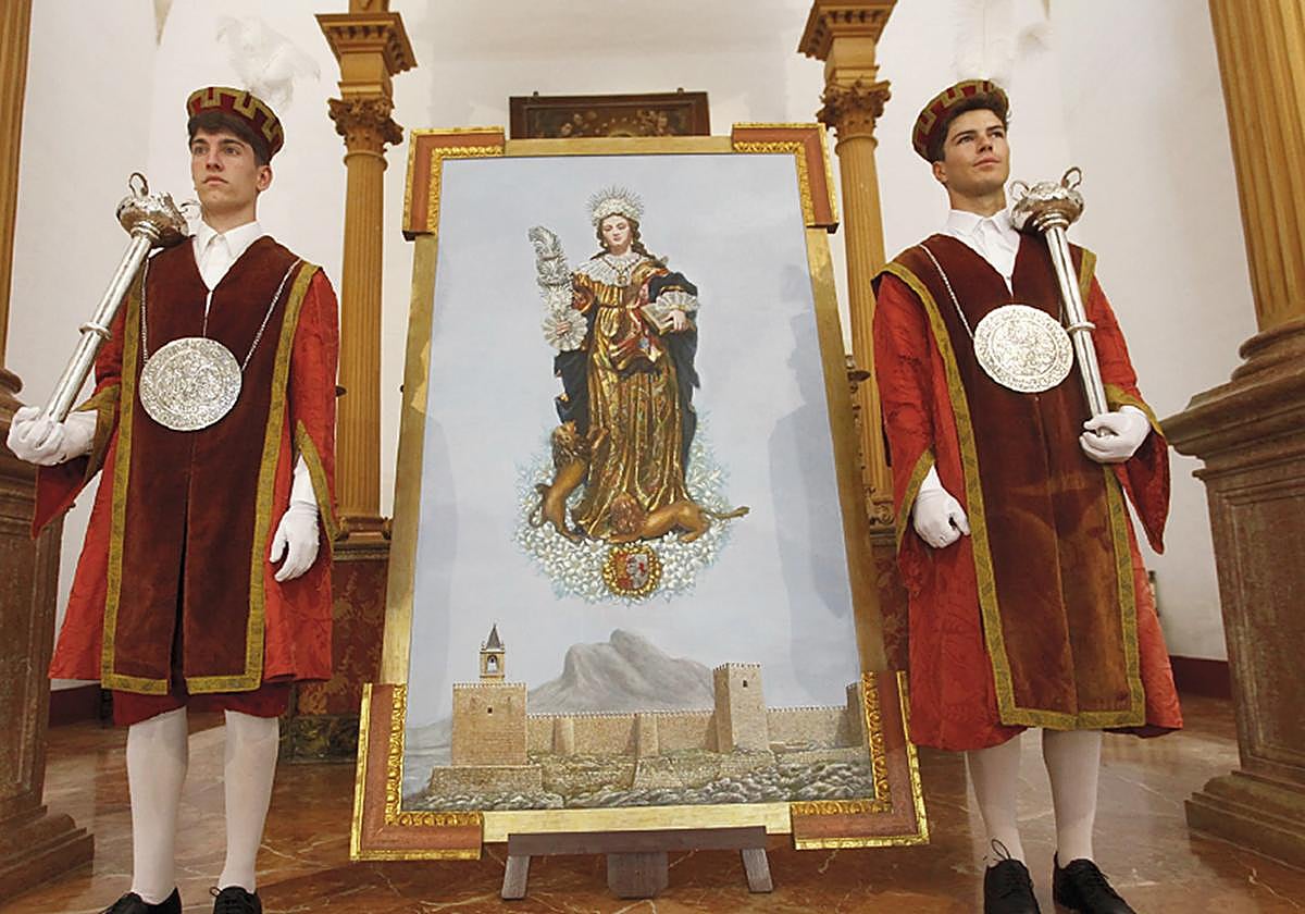 Pareja de maceros municipales ante el cuadro de Santa Eufemia que preside Santa María para la entrega de las distinciones municipales.