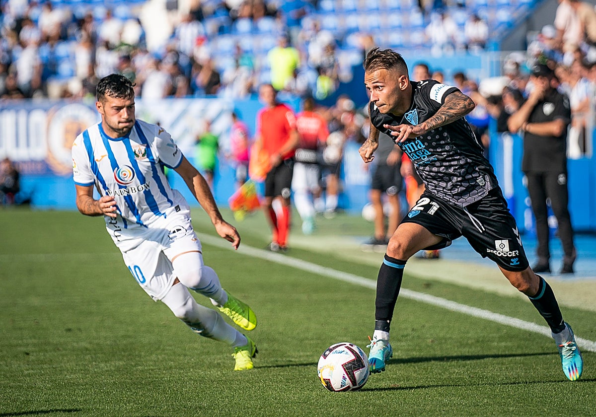 Fran Villalba conduce el balón ante la mirada de José Arnaiz, en el último Leganés-Málaga, en la 2022-23.