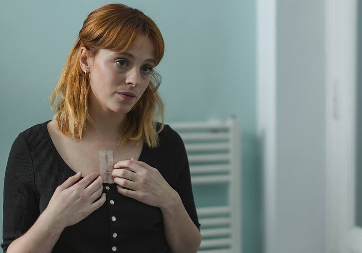 Cora Merlo, a la que encarna Catalina Sopelana, muestra la marca de su trasplante de corazón.