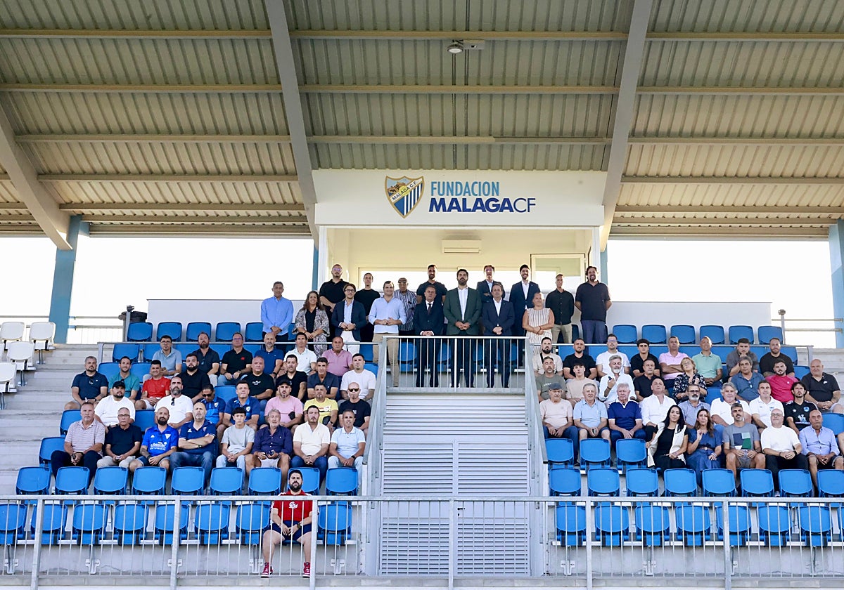 Los representantes de los clubes asistentes y dirigentes del Málaga y autoridades, en la grada principal del campo uno de la Ciudad Deportiva.