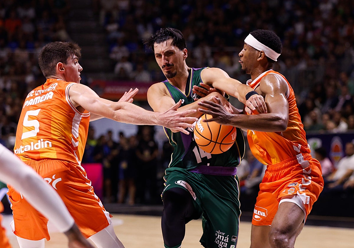 Djedovic es frenado por De Larrea y Taylor en su intento de avanzar hacia la canasta.