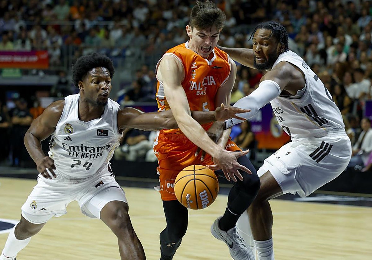 De Larrea recibe falta de dos jugadores del Madrid.