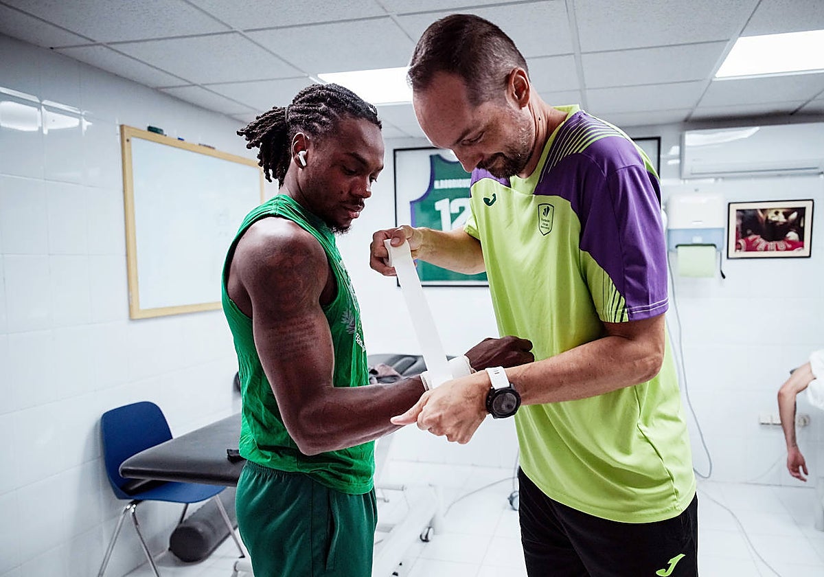 Jon Cortaberría le venda la muñeca a Perry antes de un entrenamiento.