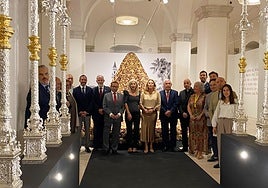 Autoridades y cofrades ante el palio y manto procesional de la Virgen de la Trinidad.