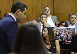 La socialista Ángeles Férriz enseña una foto de una manifestación mientras interviene Juanma Moreno