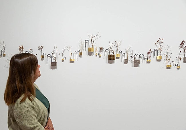 Candados que, en lugar de cerrar, se abren para dejar crecer flores y formar un paisaje.